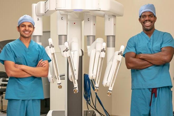 两位医生站在机器人手术设备旁边